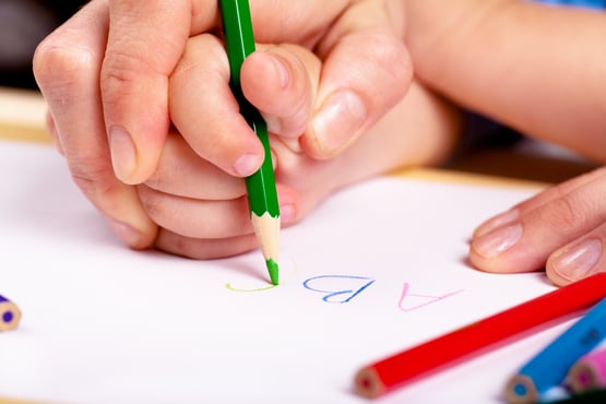 Детская рука с ручкой